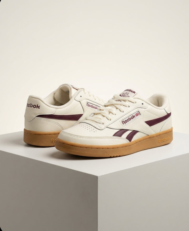 Front view of Reebok women’s white and burgundy sneakers with gum sole, size 6