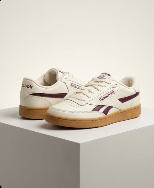 Front view of Reebok women’s white and burgundy sneakers with gum sole, size 6